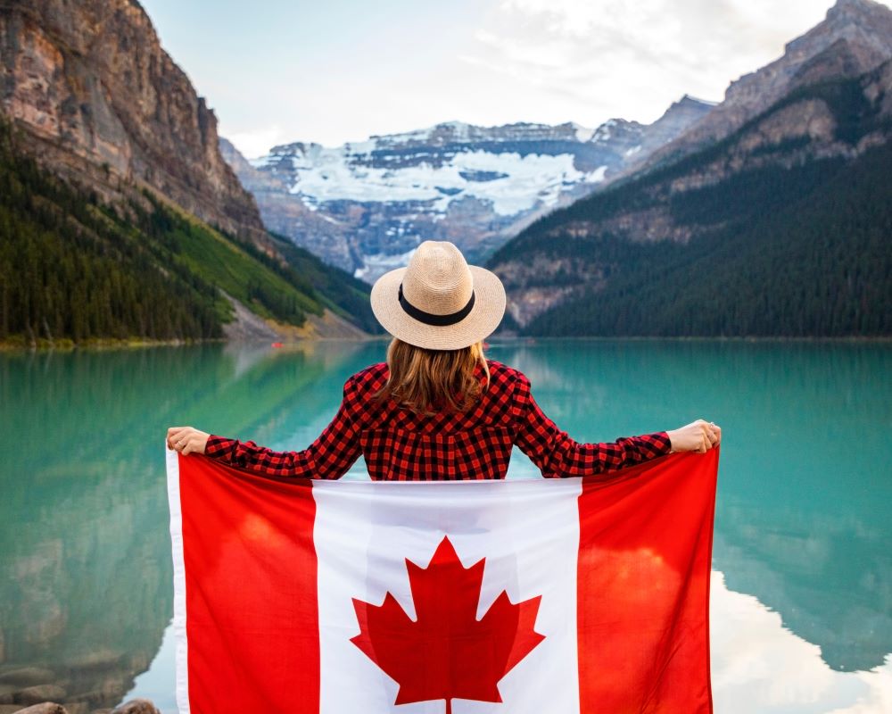 woman holding canada flag at a lake destination purrfect pilots