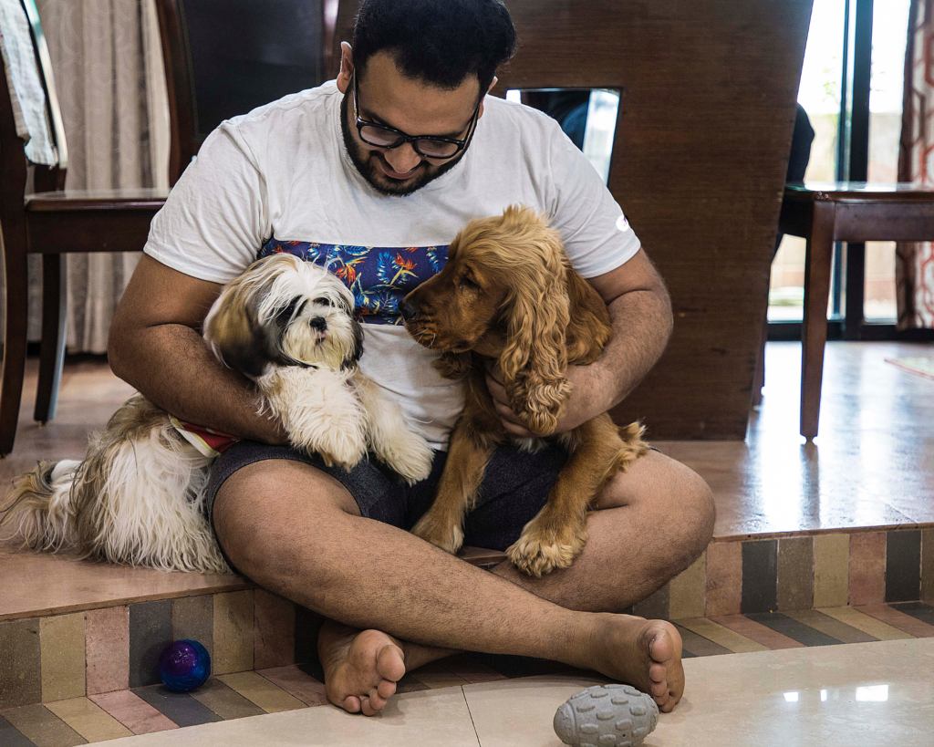 an indian man caressing two dogs bringing pets to india purrfect pilots
